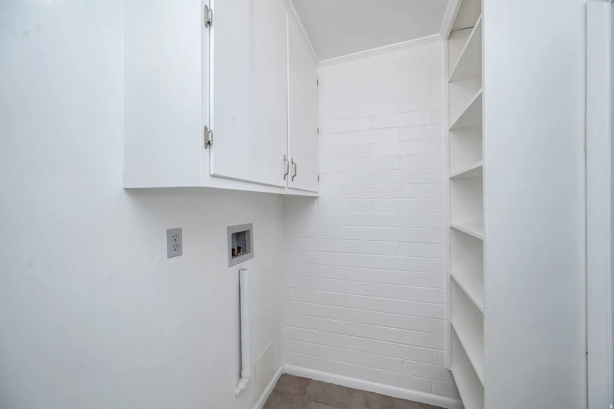 Laundry area featuring hookup for a washing machine, cabinet space, and ornamental molding