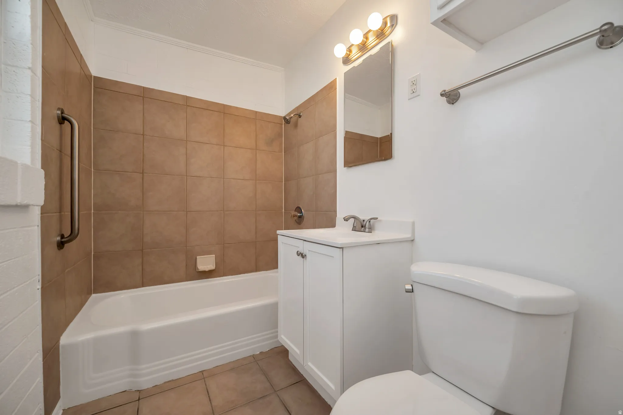 Bathroom with vanity, shower / washtub combination, and light tile patterned floors