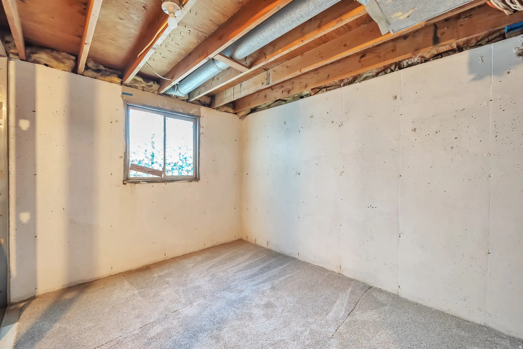 Carpeted floor with exposed ceiling joists and a functional window