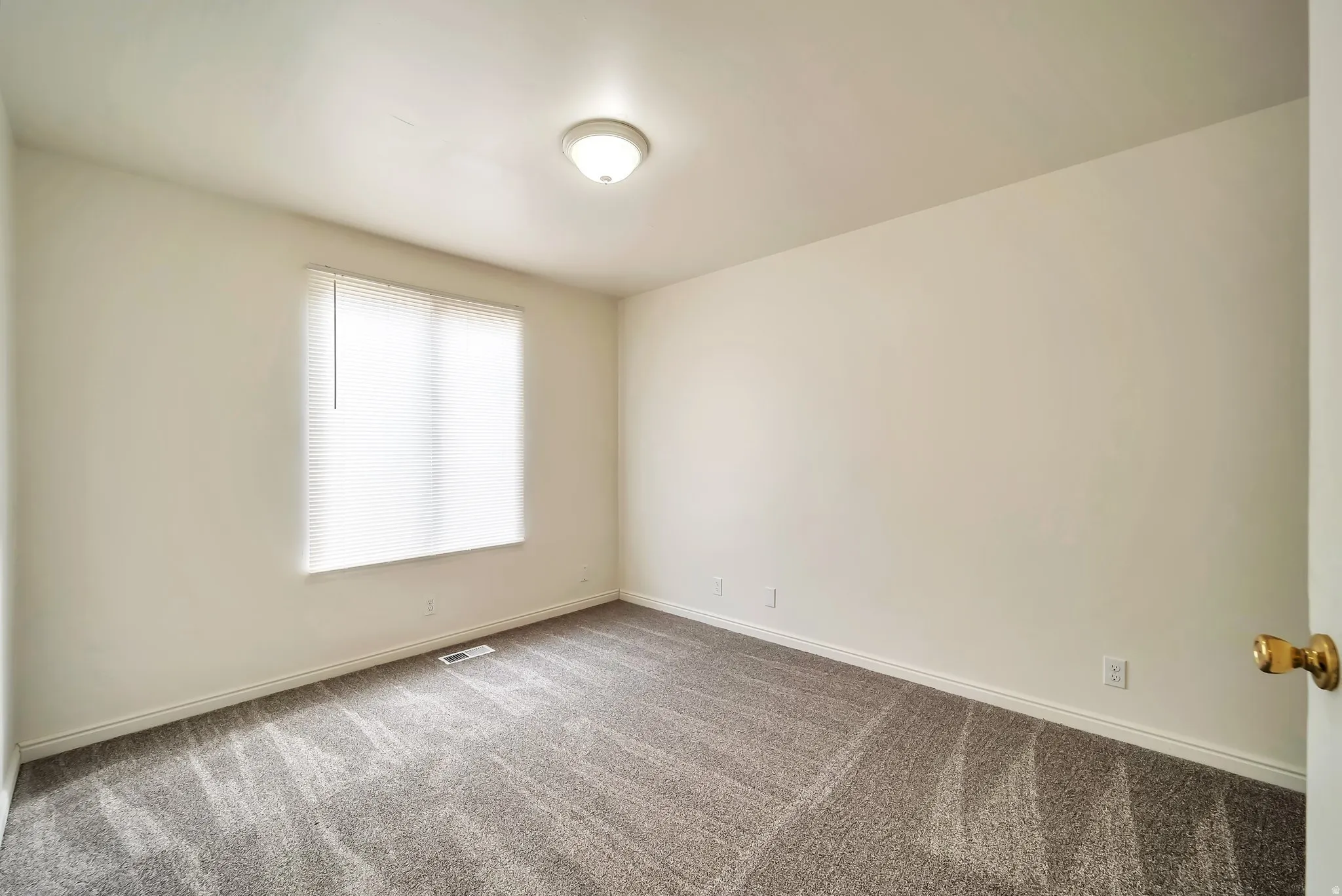 Room featuring neutral wall tones and textured carpeting