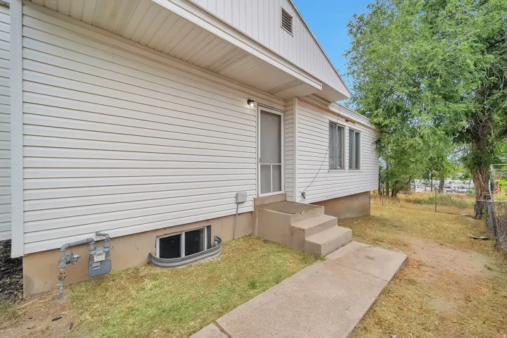 White siding exterior with concrete steps and a screen door entry