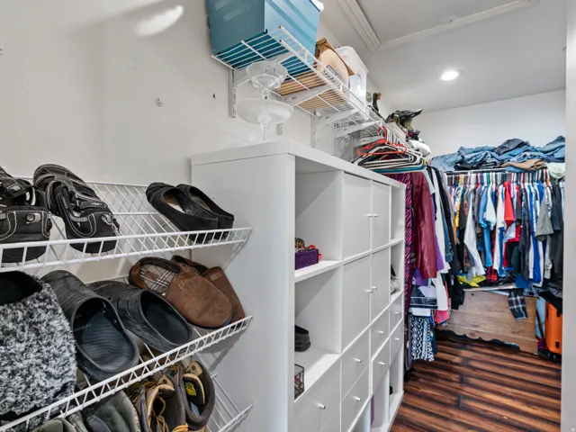 Custom closet organization system featuring white shelving, wire shoe racks, and built-in storage cubes