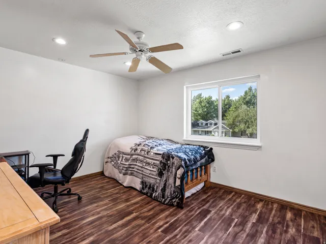 Room with wood-finish flooring, recessed lighting, and a ceiling fan