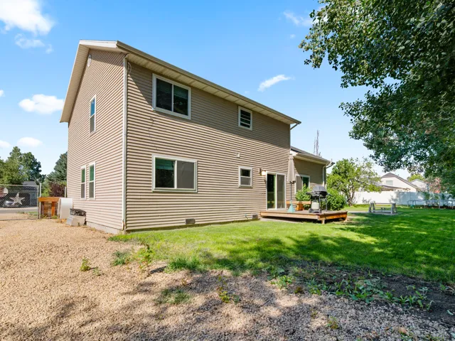 Two-story siding exterior with multiple windows and a sliding glass door leading to a wooden deck