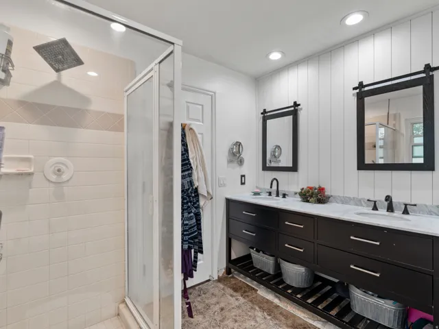 Double vanity with a marble-finish countertop, undermount sinks, and matte black fixtures