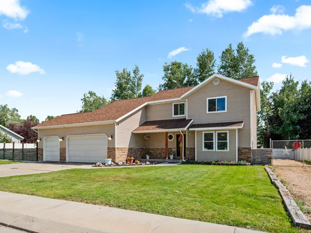 Two-story residence featuring light tan siding and a brown shingled roof