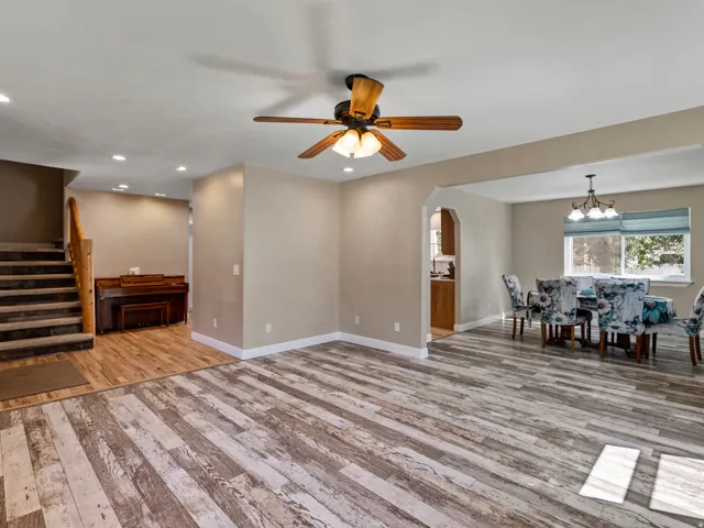 Spacious room featuring wood-finish flooring, recessed lighting, and a ceiling fan