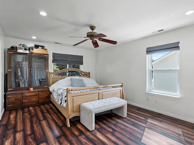 Spacious room featuring wood-finish flooring, recessed ceiling lighting, and a ceiling fan