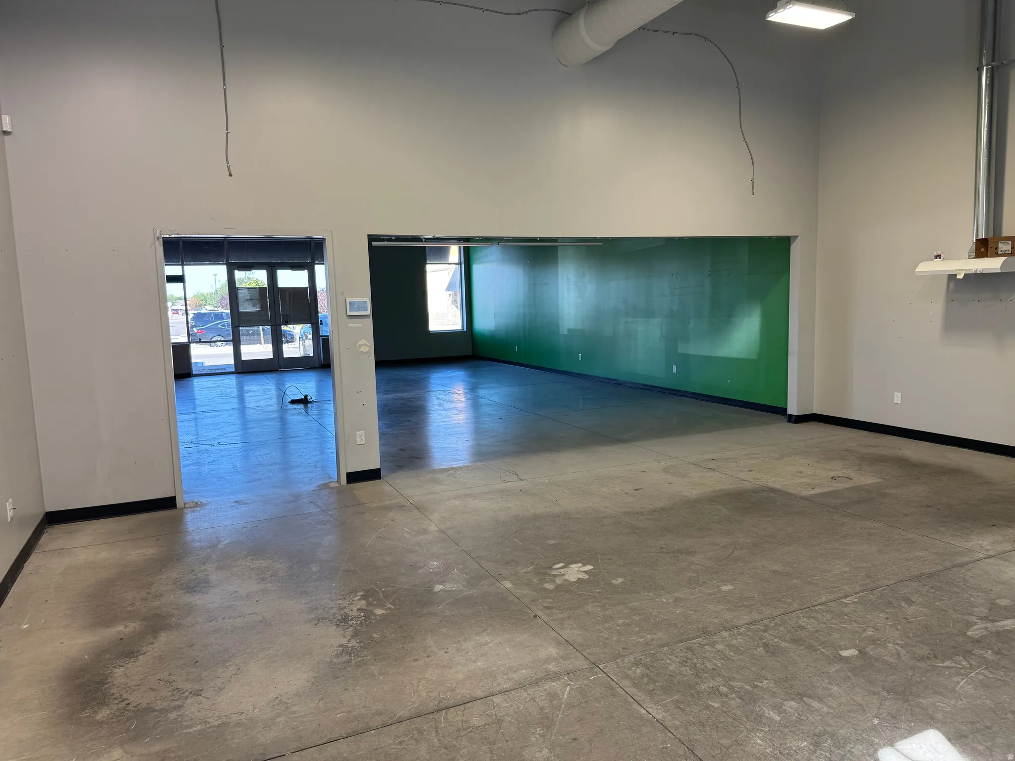 Spacious interior with concrete flooring and light gray walls