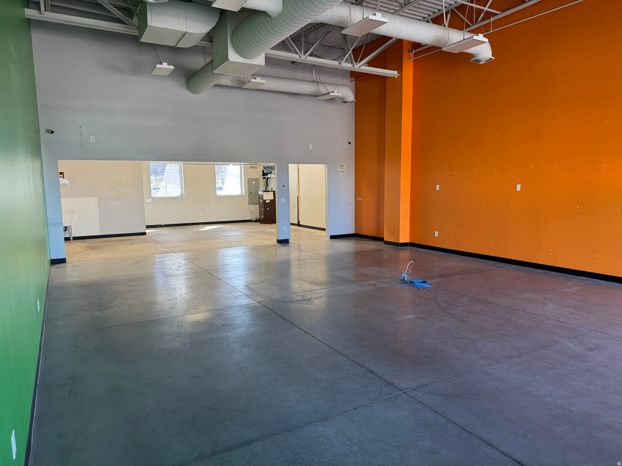 Expansive open-concept commercial space featuring concrete flooring and high exposed ceilings
