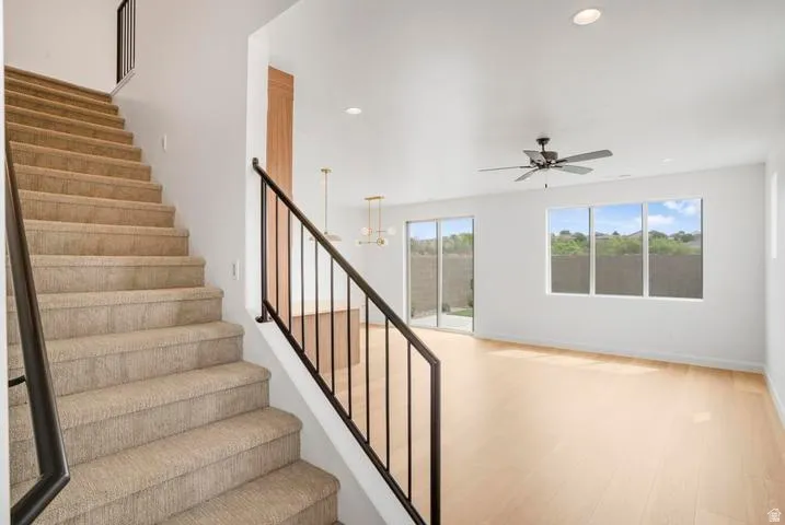 Carpeted staircase with dark metal railings