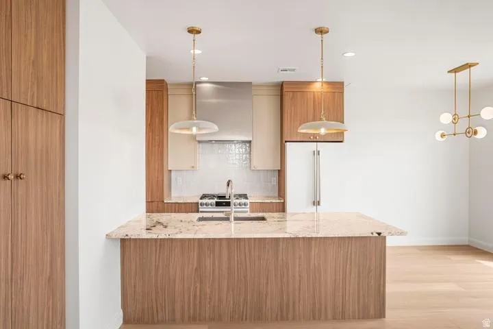 Modern kitchen featuring a central island with a granite countertop and integrated sink