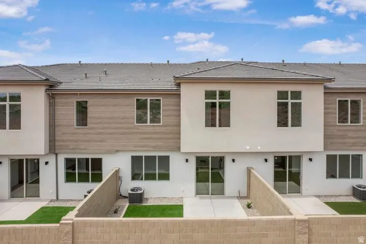Contemporary multi-level townhome featuring a stucco and wood-finish exterior