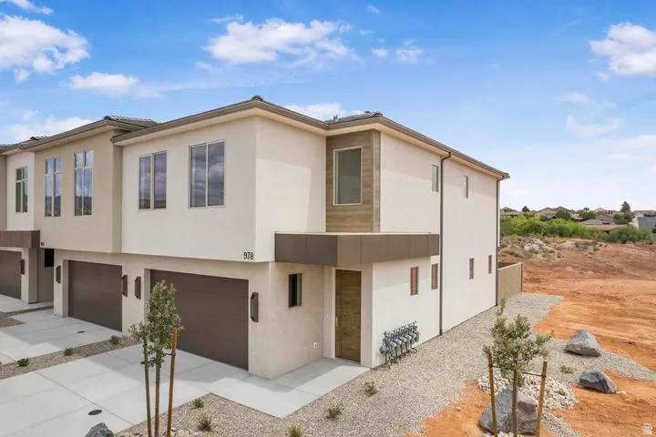 Contemporary multi-story exterior with stucco finish and prominent dark brown garage doors