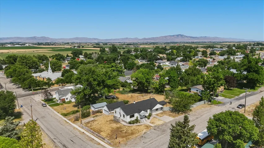 Aerial perspective featuring the property with a white exterior, black roof, and adjacent outbuilding