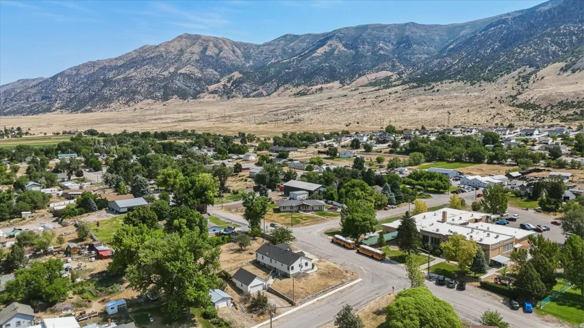 Aerial perspective showcasing a residential area with a prominent school building, surrounded by mature trees