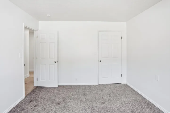 Neutral white walls with textured gray carpeting