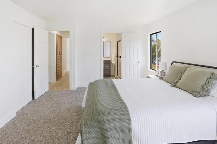 Bedroom featuring neutral-toned carpeting and a large window