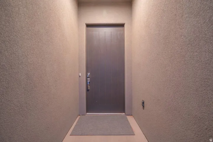 Doorway to property featuring stucco siding