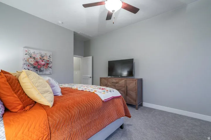 Carpeted bedroom with baseboards and ceiling fan