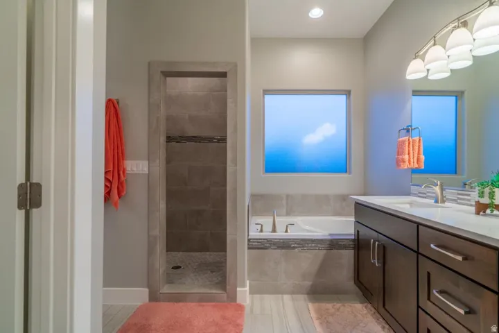 Bathroom with vanity, a garden tub, walk in shower, and recessed lighting