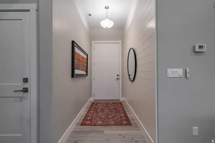 Entryway featuring wood finished floors and wooden walls