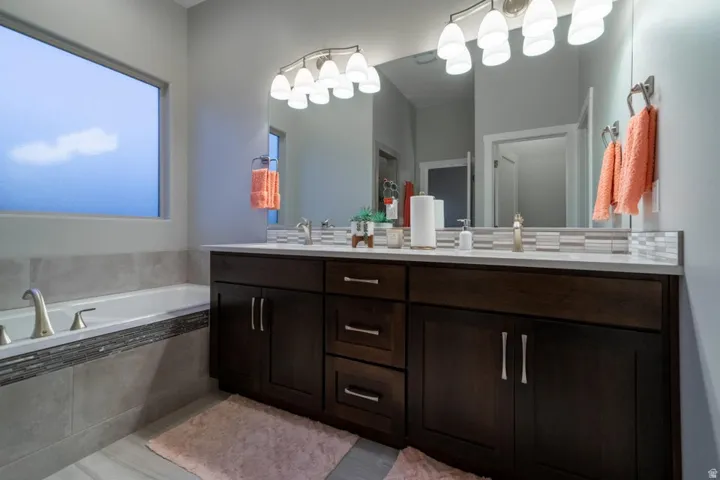 Full bathroom featuring double vanity and a garden tub