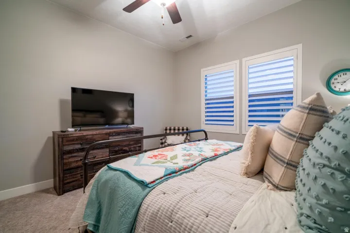 Carpeted bedroom featuring baseboards and ceiling fan