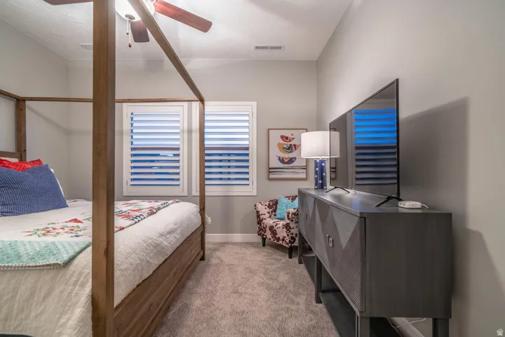 Bedroom with light carpet and ceiling fan
