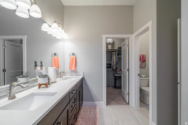 Full bath with double vanity and a spacious closet
