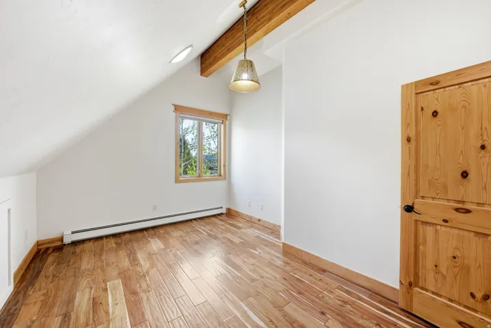 Wood-finish flooring with natural wood trim and solid wood interior door