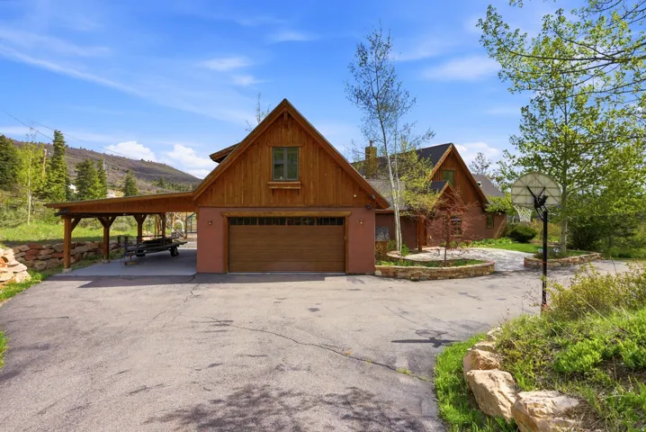 Wood-sided home featuring an attached garage and a covered carport
