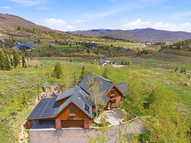 Mountain property featuring a multi-level design with brown siding and a dark roof