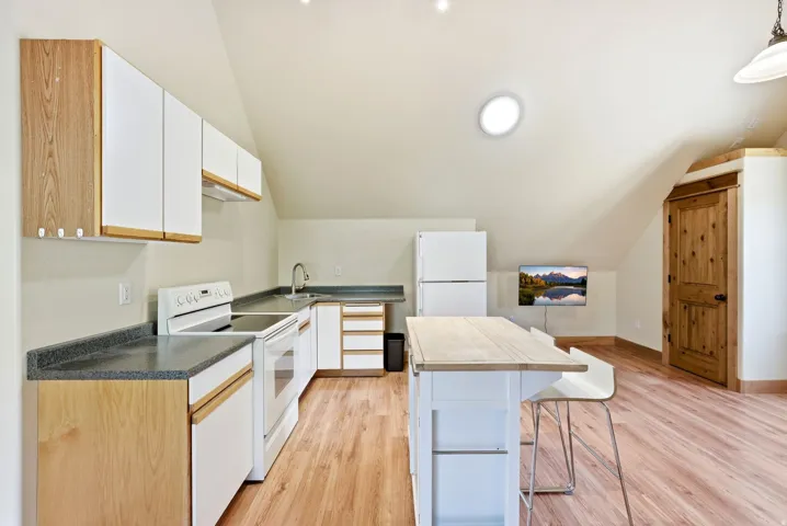 Kitchenette featuring a full-size range, refrigerator, and a built-in island with seating
