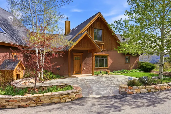 Crafted exterior featuring a rich stucco finish with wood siding and trim accents