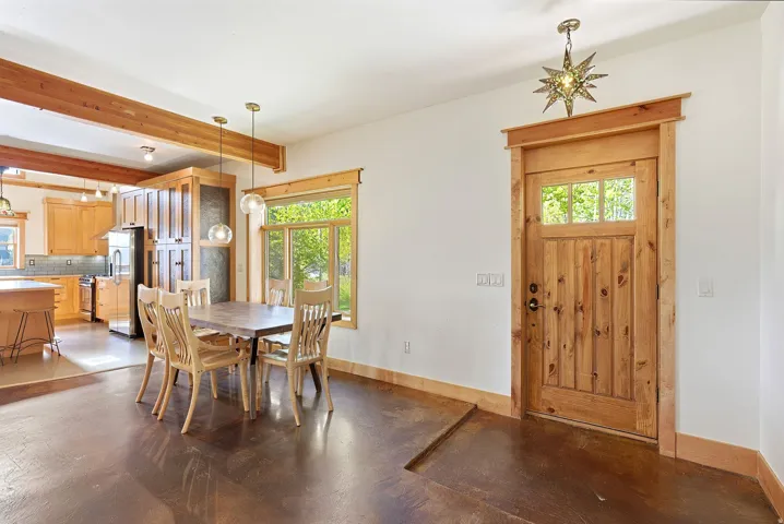 Hardwood flooring with a natural wood-finish entry door featuring upper glass panels and custom trim