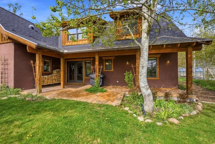 Terracotta-hued exterior featuring a covered patio with exposed wood beams and columns