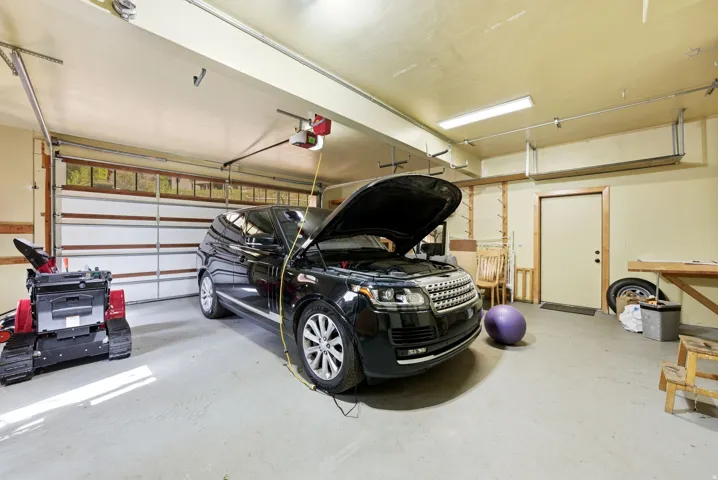 Spacious garage featuring a concrete floor, two overhead garage doors with window panels, and interior access door