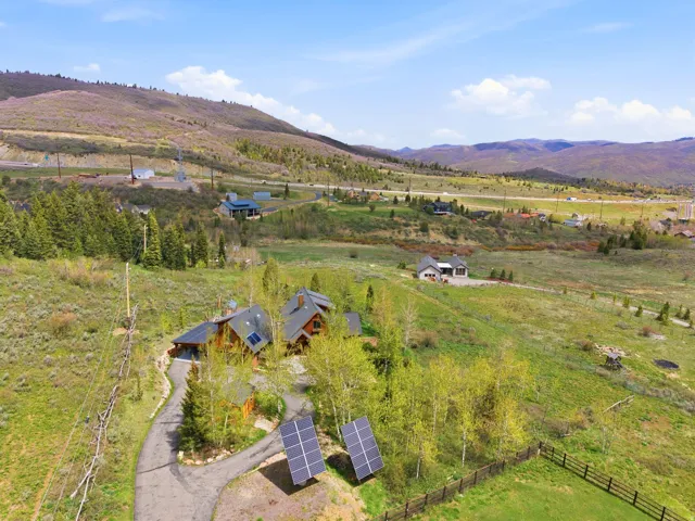 Expansive natural terrain surrounding a property with a paved drive