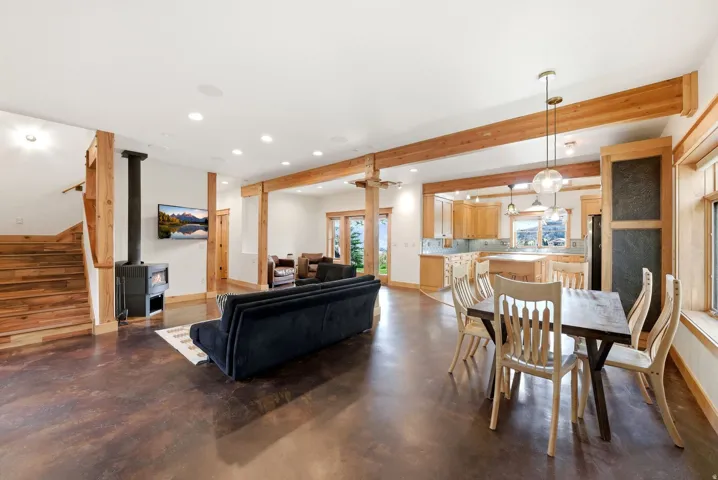 Open-concept room featuring wood-finish flooring and exposed timber beams