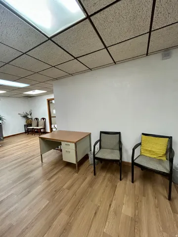 Wood-finish flooring throughout, featuring a drop ceiling with integrated fluorescent lighting