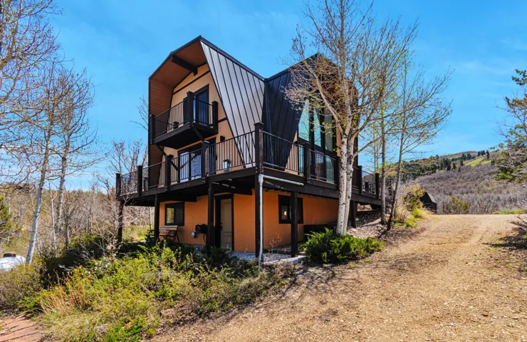 Contemporary A-frame residence featuring multiple balconies and expansive windows