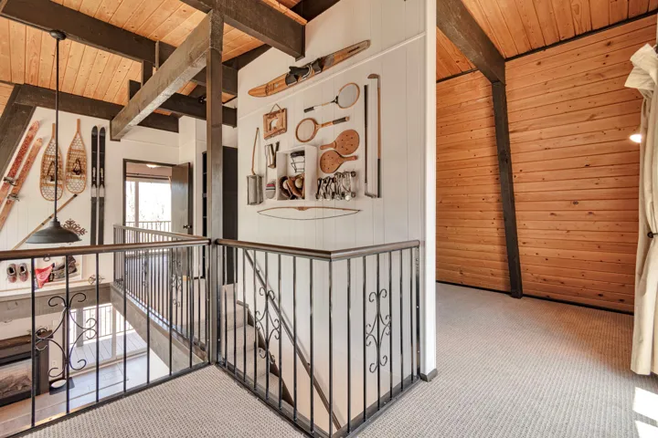 Upper-level landing featuring textured carpet flooring and wrought iron railings