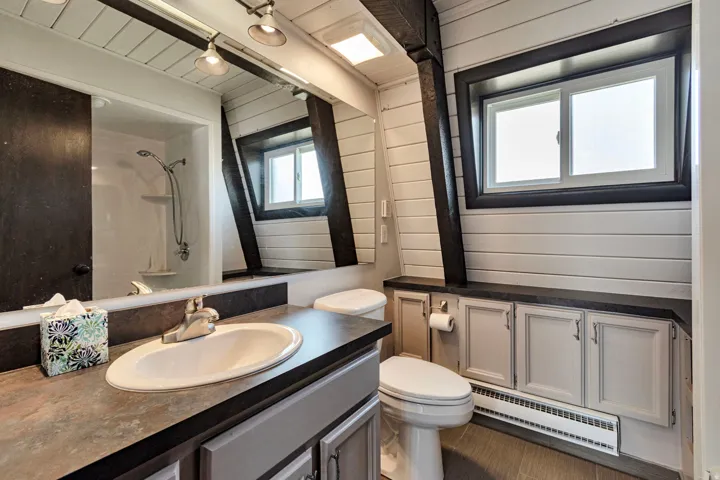 Bathroom vanity with integrated sink, dark countertop, and built-in cabinetry