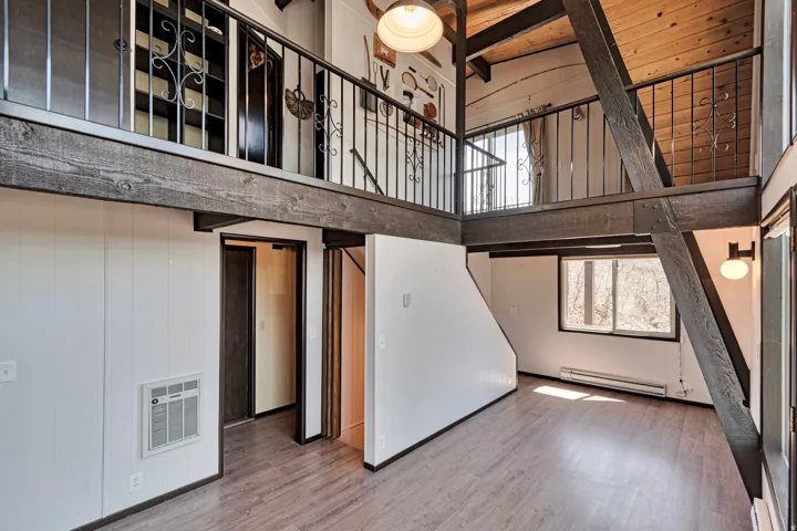 Interior featuring exposed architectural beams and wood-finish flooring