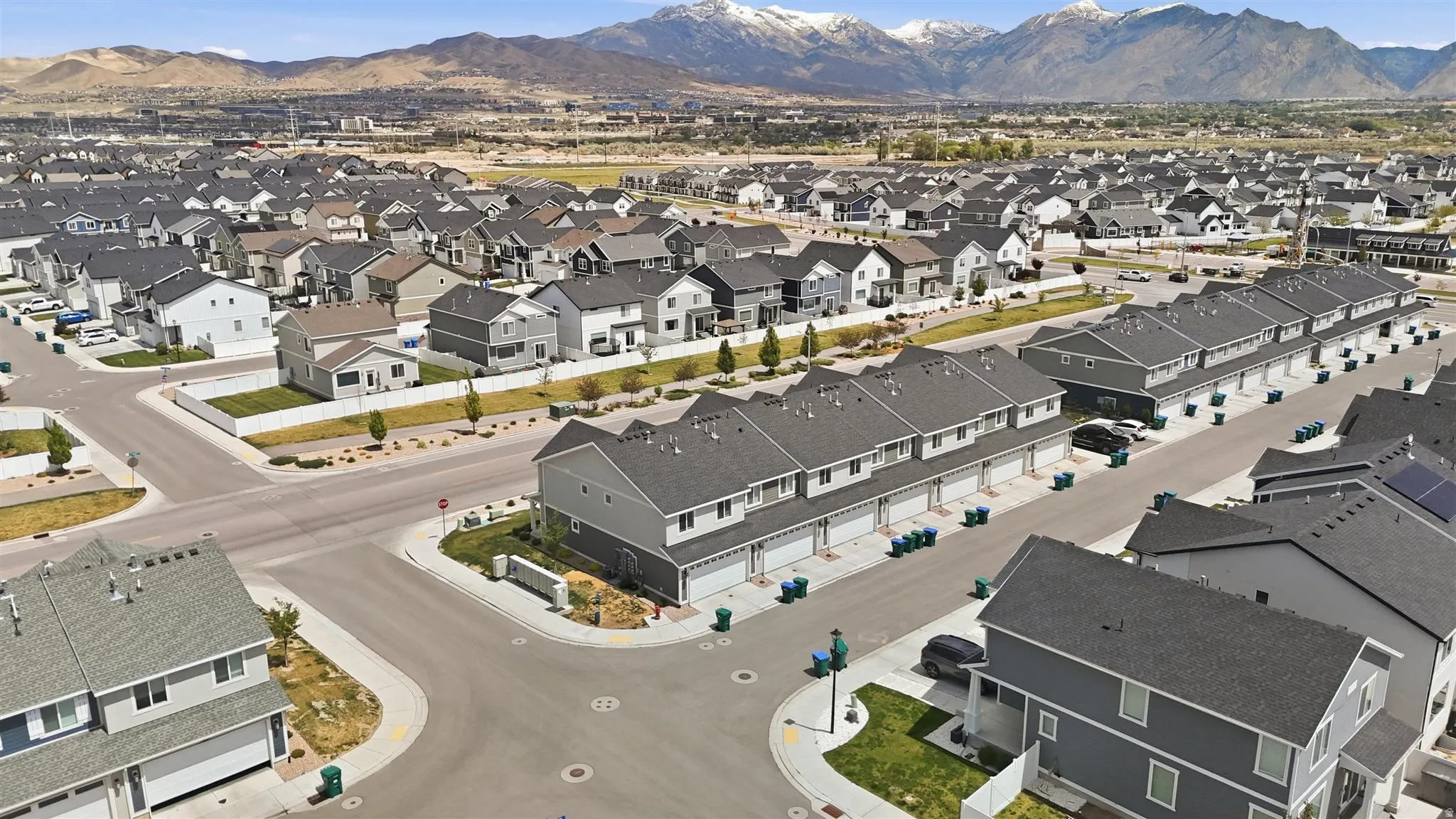 Expansive residential development featuring a mix of single-family homes and townhomes, set against a backdrop of distant mountains