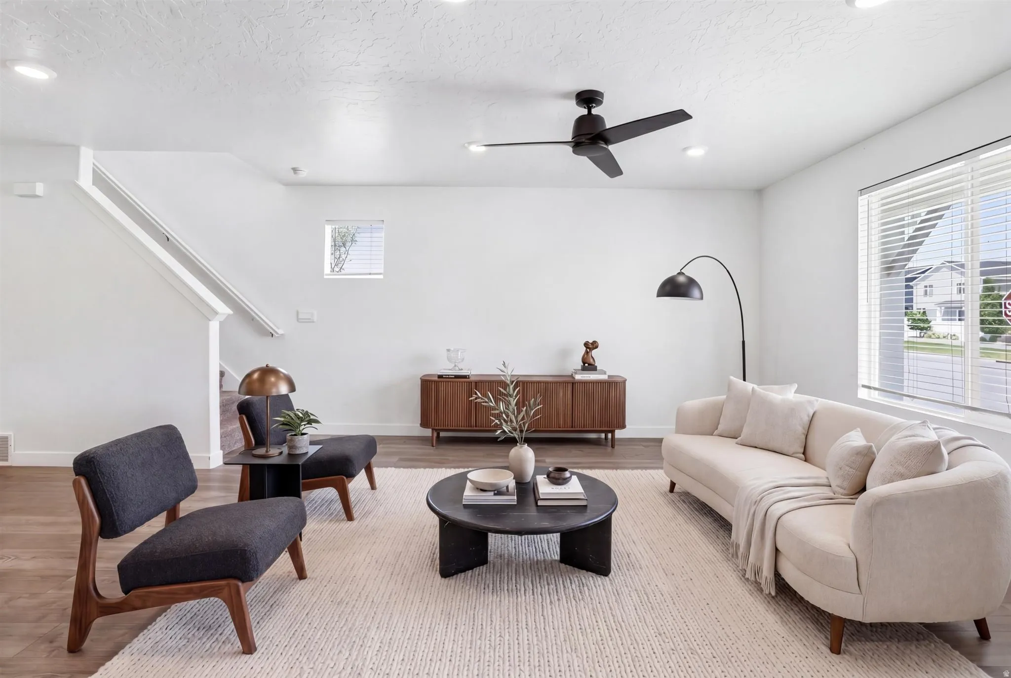 Open-concept living space with wood-finish flooring and a neutral color palette