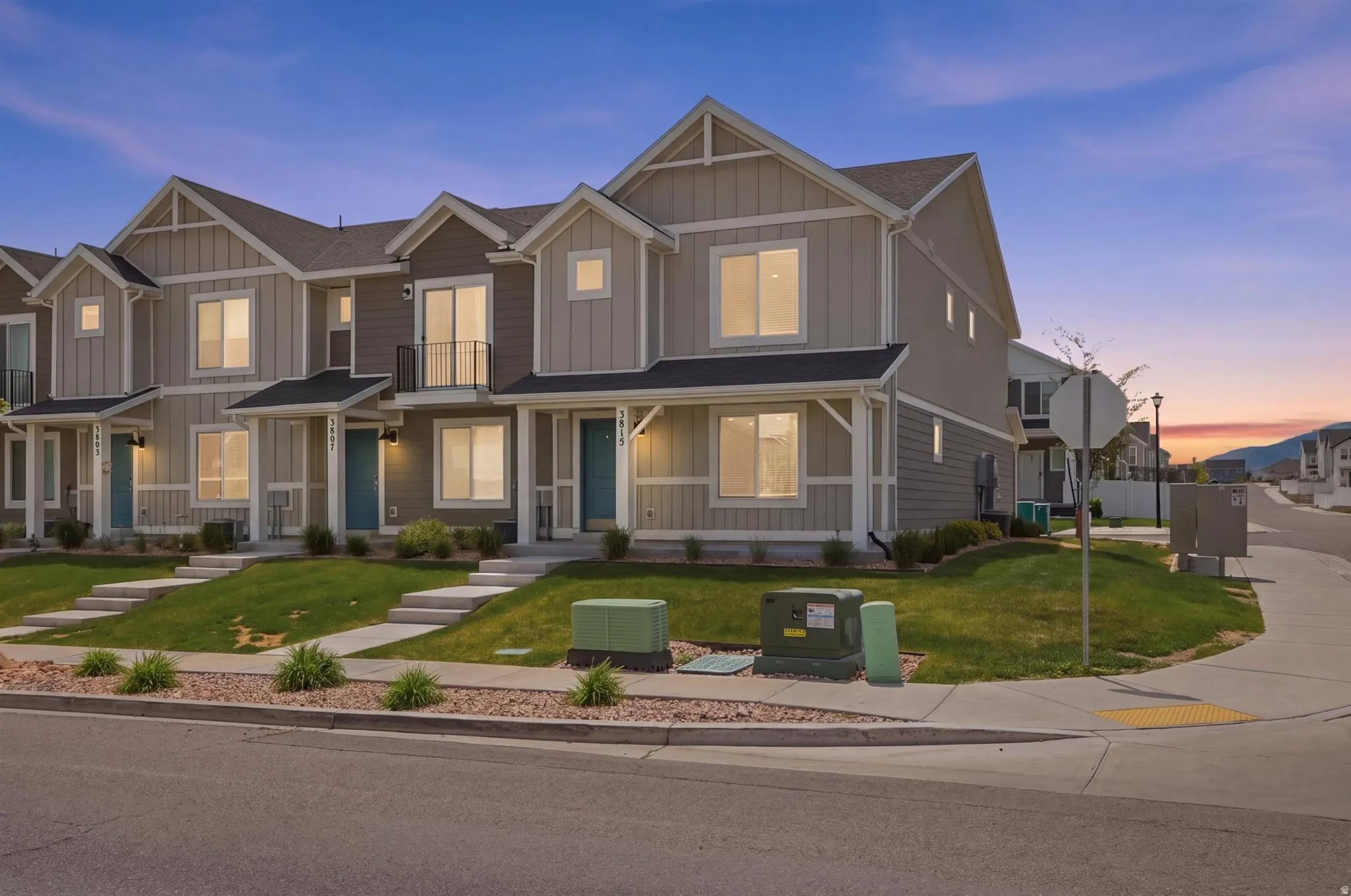Contemporary townhomes featuring a multi-tone facade, gabled roofs, and manicured lawns