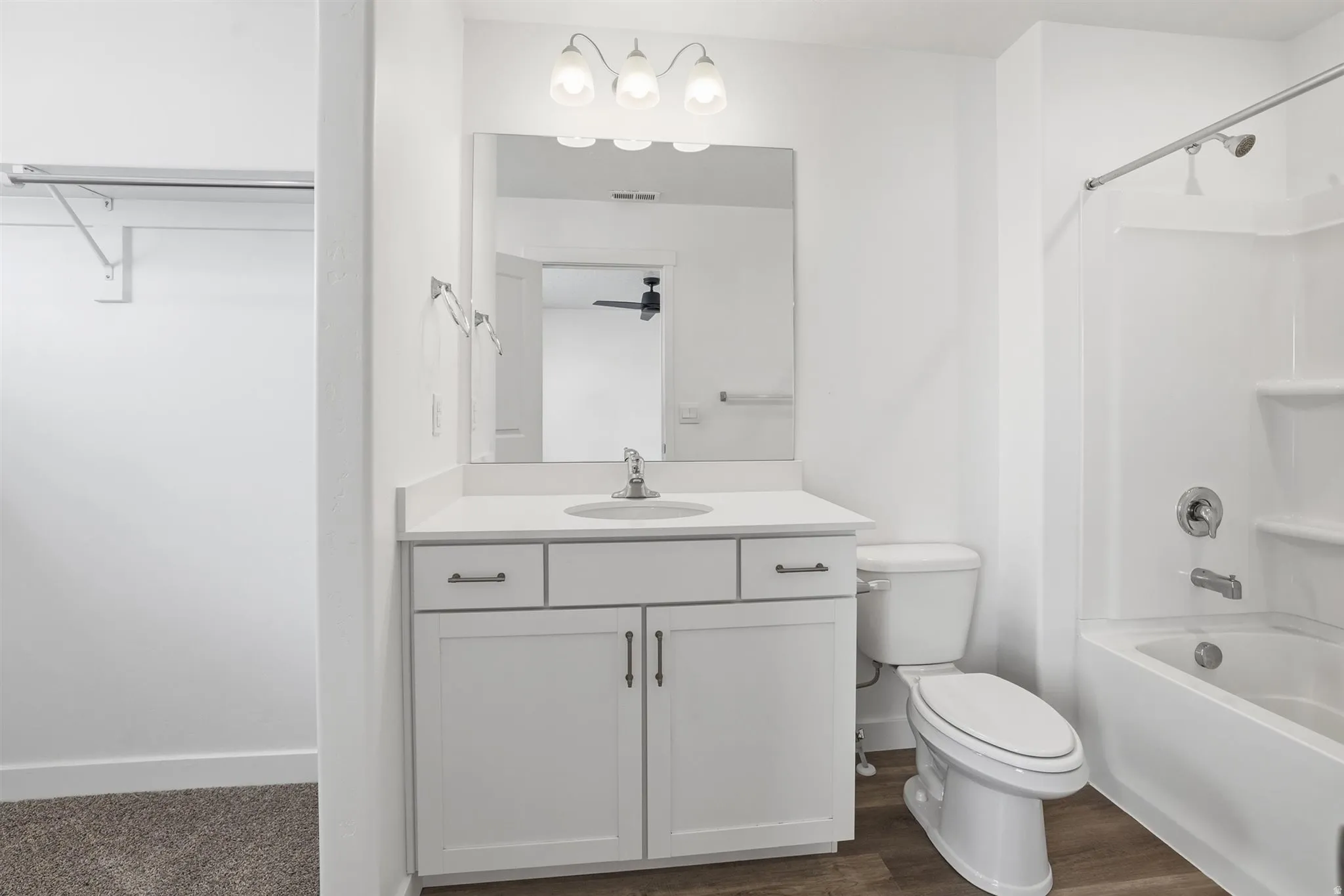 Bathroom featuring a white vanity with a light countertop, integrated sink, and brushed nickel hardware