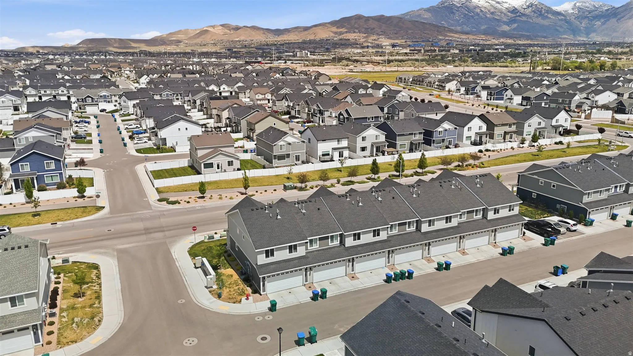 Aerial perspective showcasing a developed residential community with a mix of single-family homes and townhomes, featuring paved streets and manicured landscaping